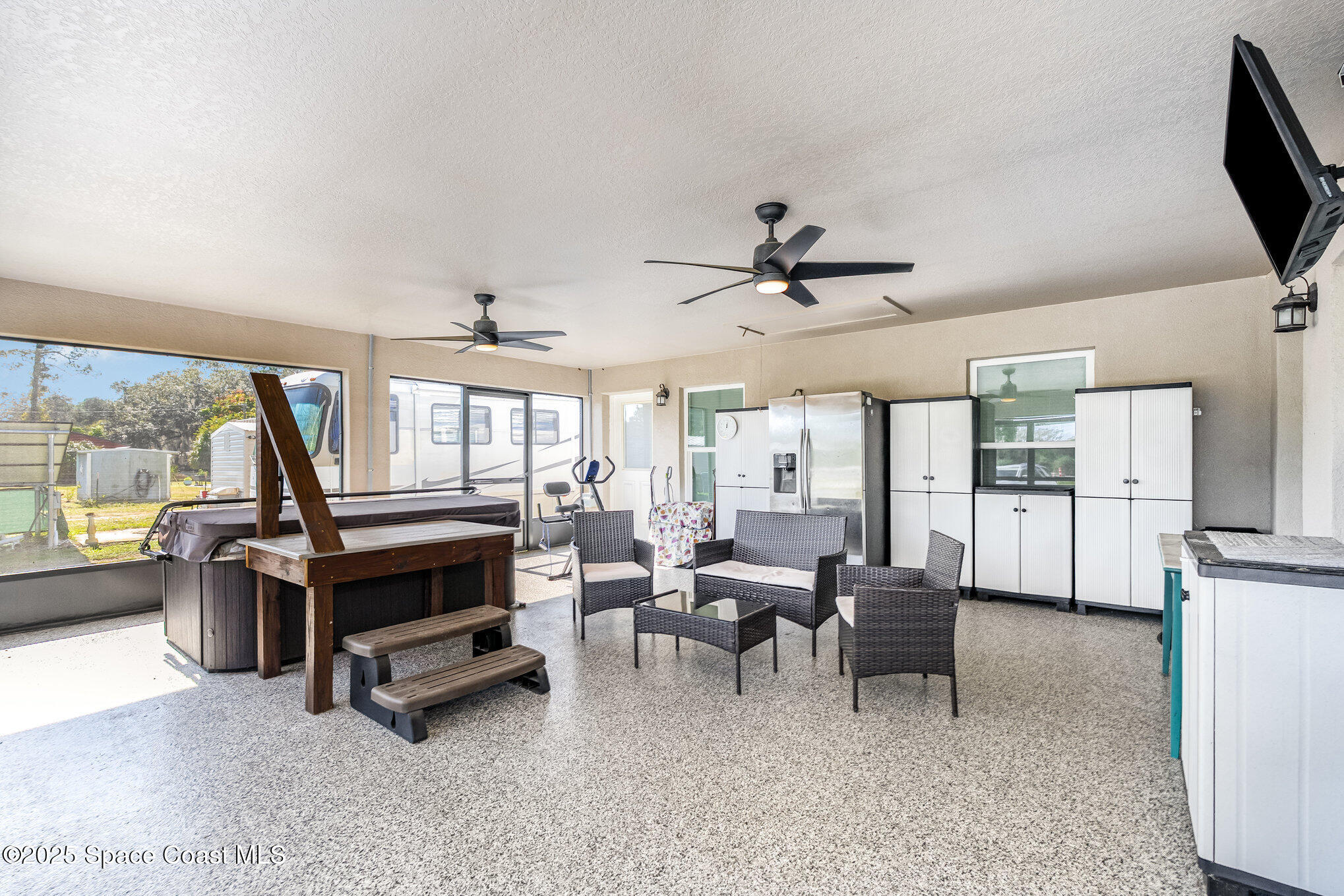 6786 U.S. Rte 1 Mims, FL 32754 - Photo 2 of 33 a living room with furniture a ceiling fan and a flat screen tv