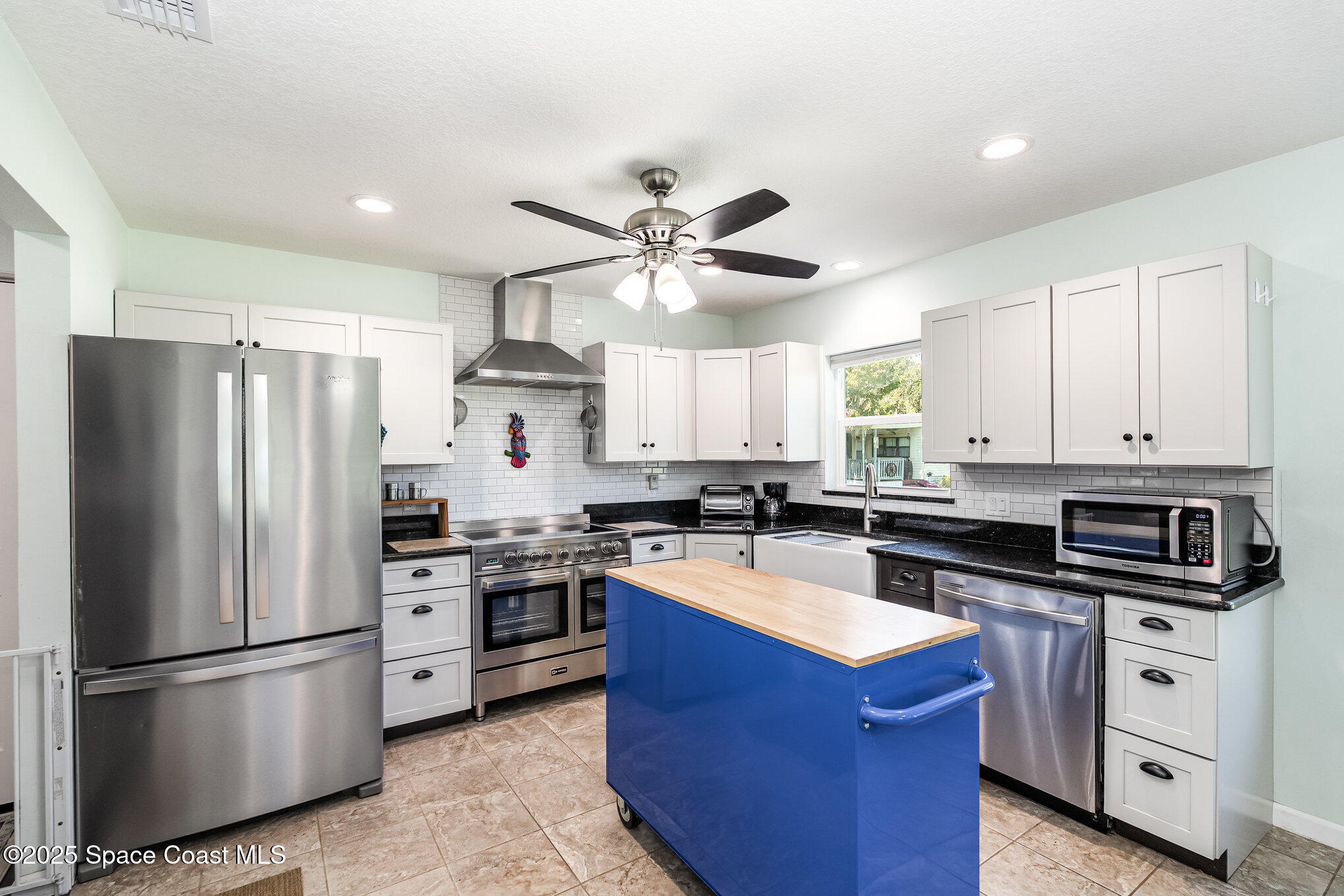 6786 U.S. Rte 1 Mims, FL 32754 - Photo 7 of 33 a kitchen with stainless steel appliances granite countertop a stove a refrigerator a sink a stove with white cabinets