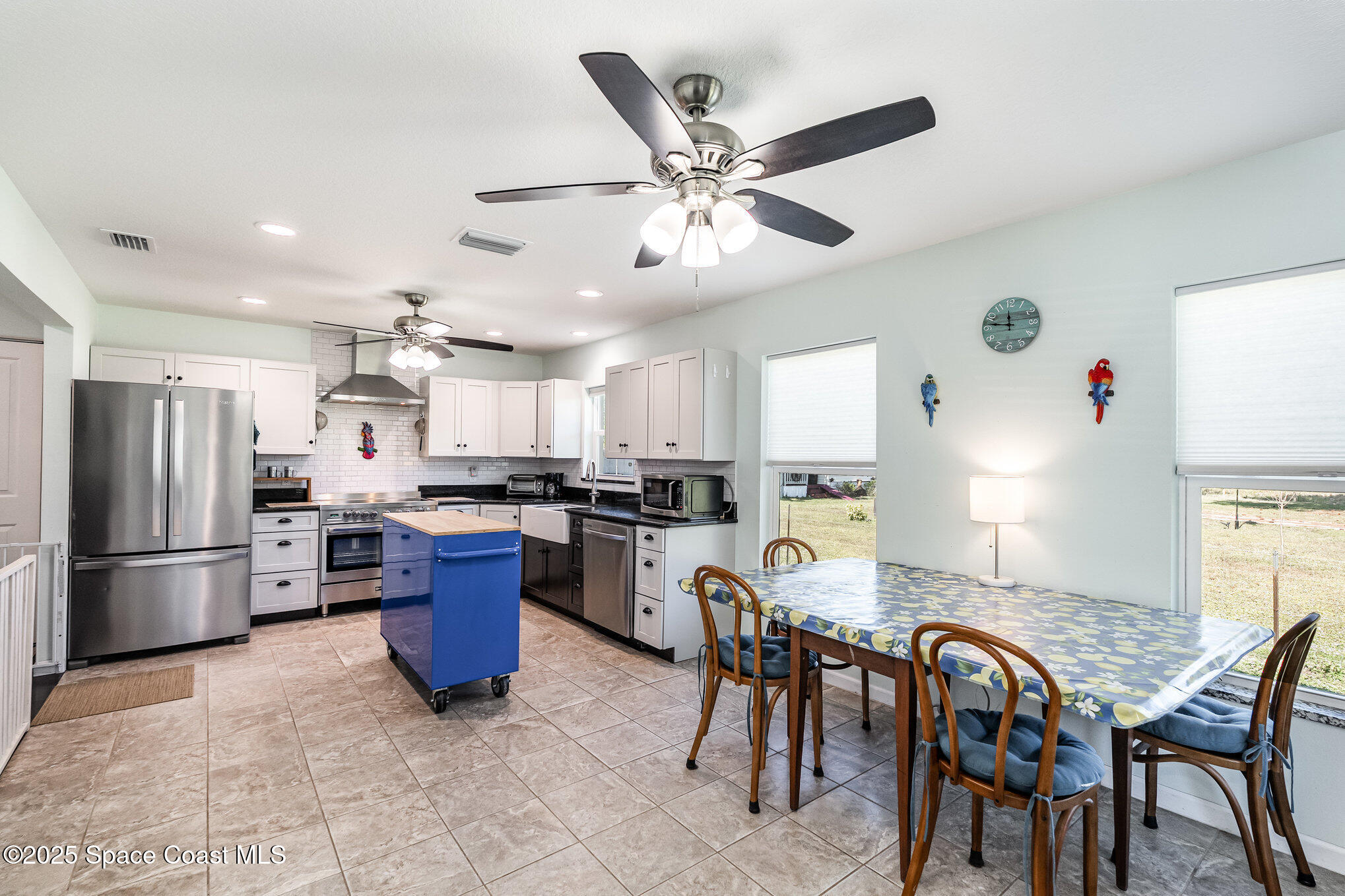 6786 U.S. Rte 1 Mims, FL 32754 - Photo 8 of 33 a kitchen with stainless steel appliances kitchen island granite countertop a table chairs microwave and refrigerator