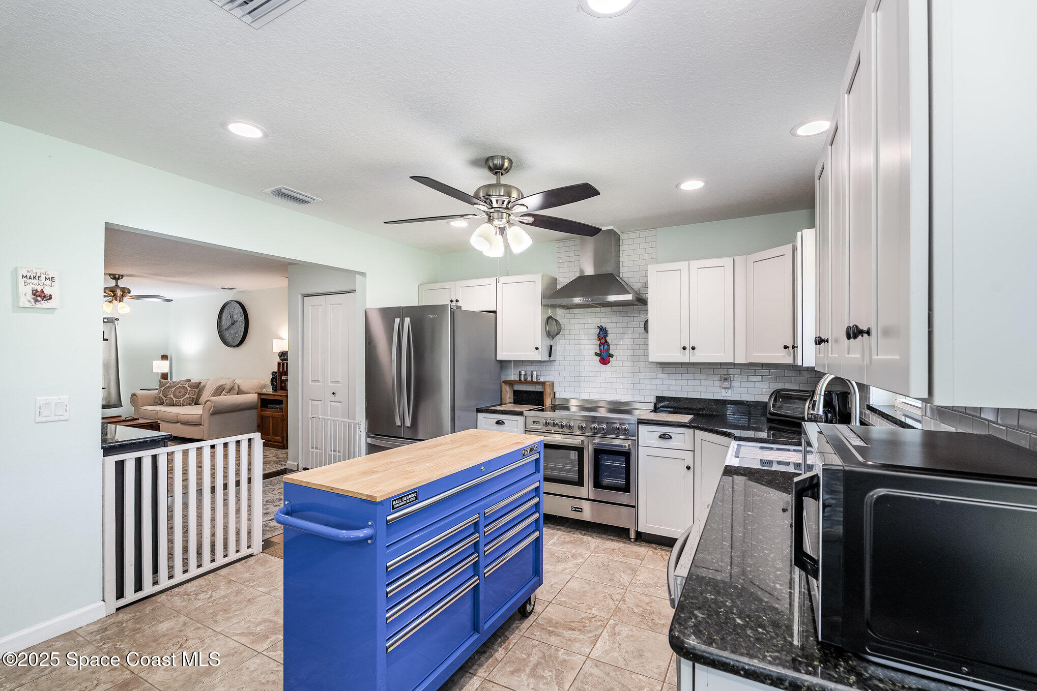 6786 U.S. Rte 1 Mims, FL 32754 - Photo 9 of 33 a kitchen with stainless steel appliances kitchen island granite countertop a stove a sink dishwasher and a refrigerator with wooden floor