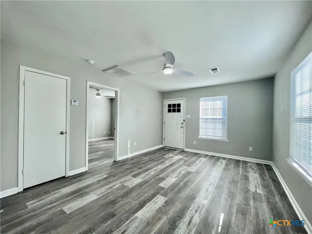 wooden floor in an empty room with a window