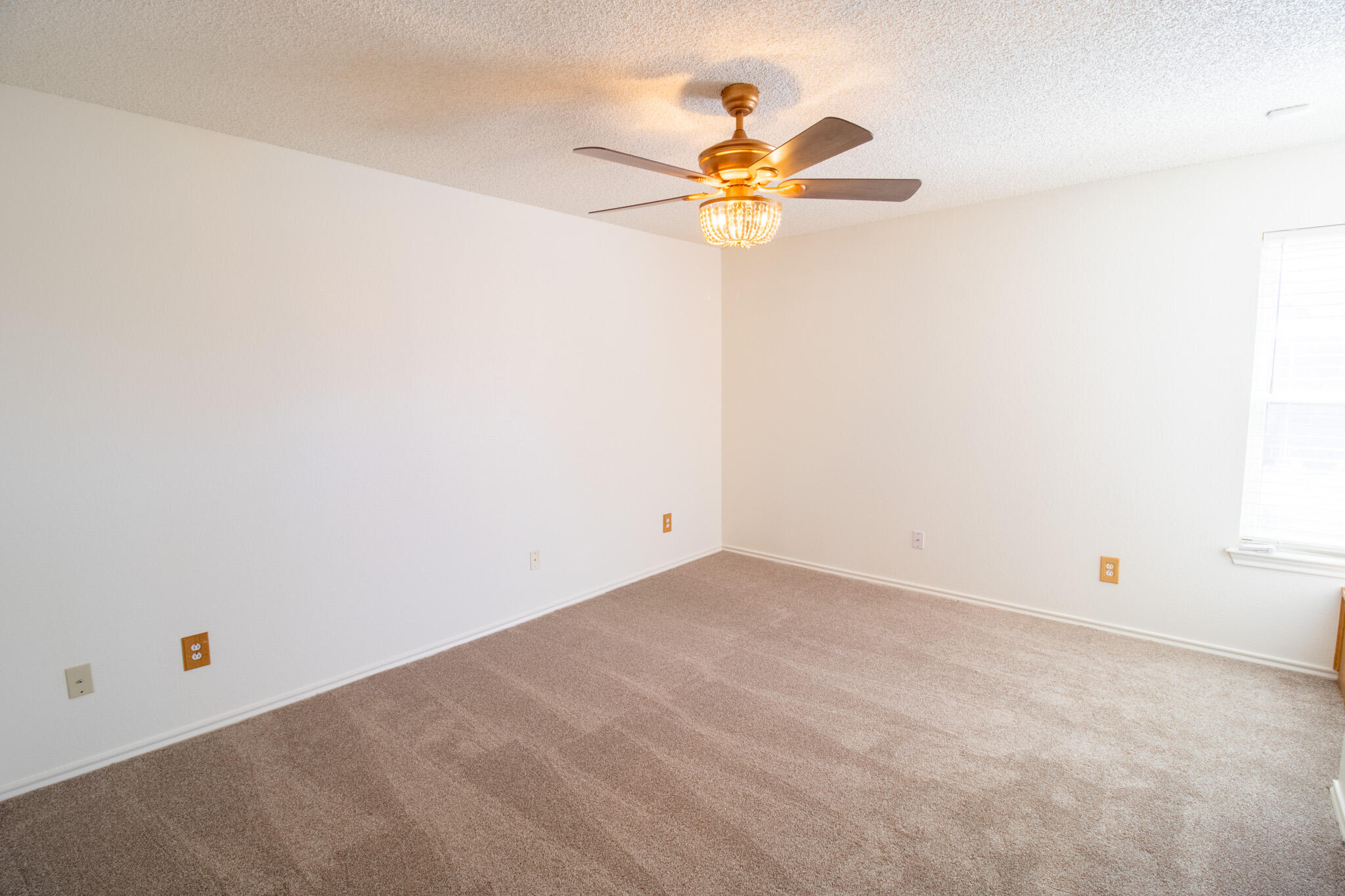 5731 95th Street Lubbock, TX 79424 - Photo 11 of 15 an empty room with a chandelier fan and closet