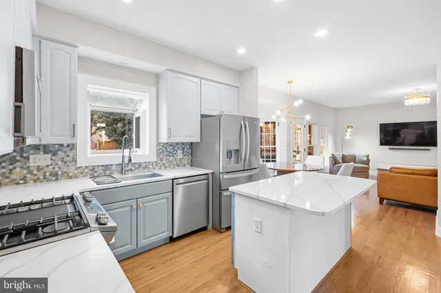 a dining room with furniture a livingroom view and wooden floor