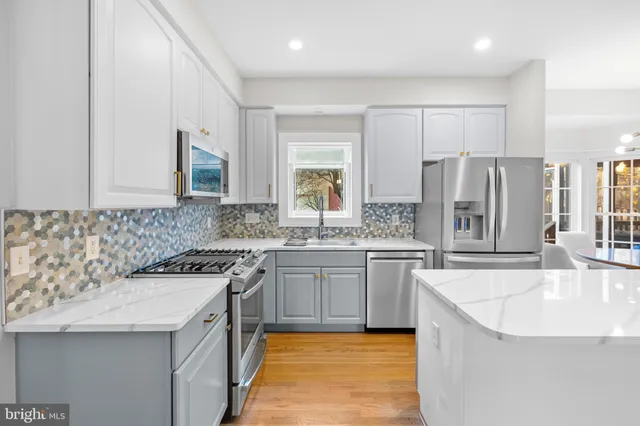 a kitchen with a sink a microwave a refrigerator and cabinets