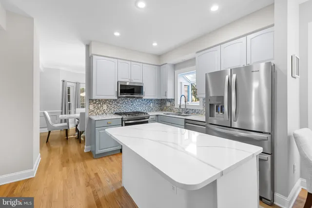 a large kitchen with a refrigerator sink and stove top oven