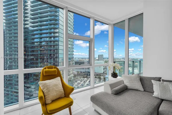 a living room with furniture and a floor to ceiling window