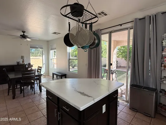 a kitchen with stainless steel appliances a table chairs and windows