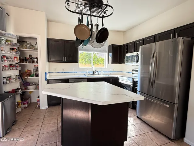 a kitchen with stainless steel appliances granite countertop a sink and a refrigerator