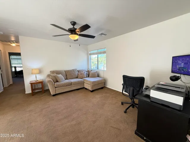 a living room with furniture and a ceiling fan