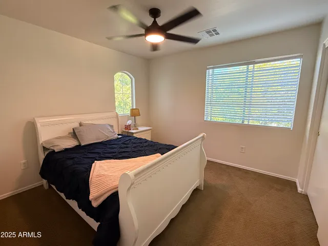 a bedroom with a bed and a ceiling fan