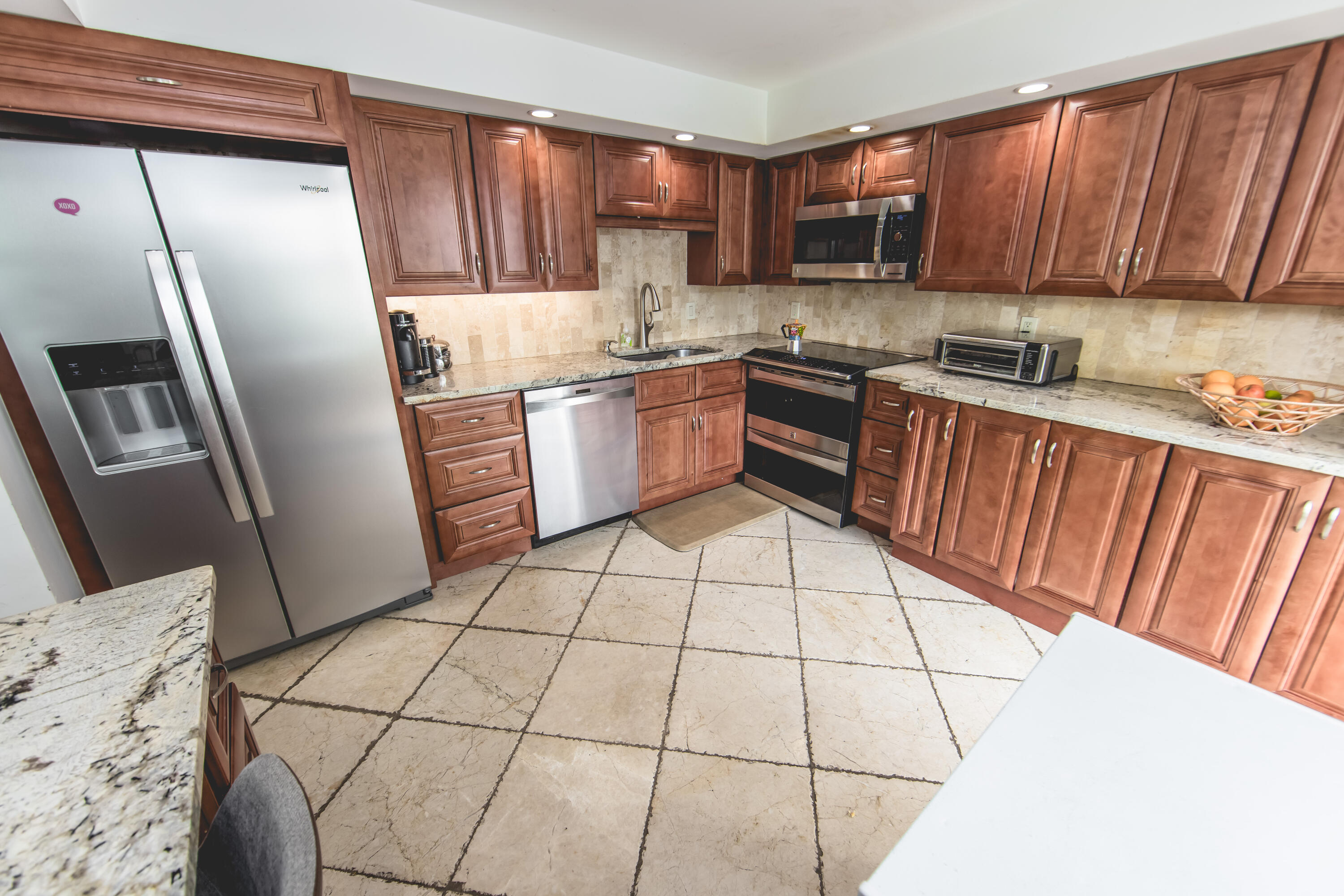 501 Southwest 11th Place, Unit 101 Boca Raton, FL 33432 - Photo 12 of 22 a kitchen with a refrigerator sink and cabinets