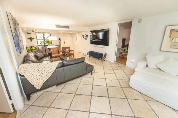 a bedroom with a bed and a potted plant on the dresser