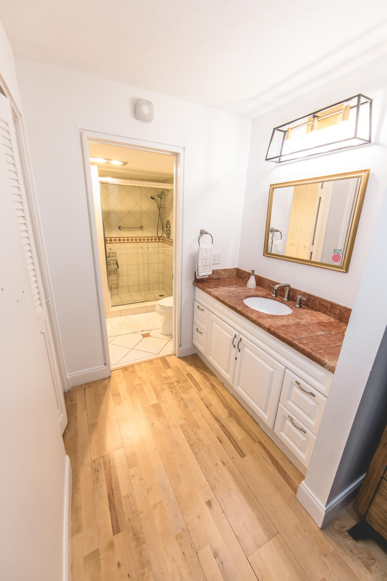 501 Southwest 11th Place, Unit 101 Boca Raton, FL 33432 - Photo 20 of 22 a bathroom with a granite countertop sink and a mirror