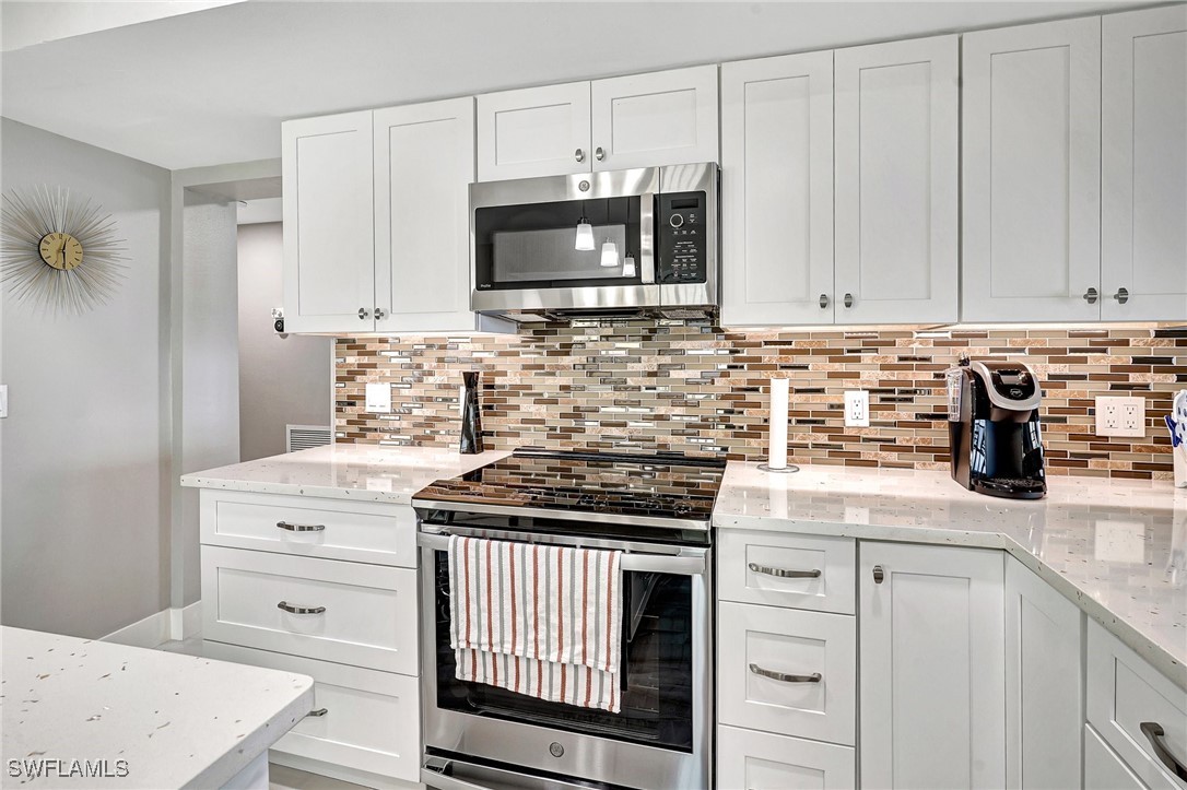 1900 Virginia Avenue, Unit 103 Fort Myers, FL 33901 - Photo 14 of 45 a kitchen with stainless steel appliances granite countertop a stove a microwave and cabinets
