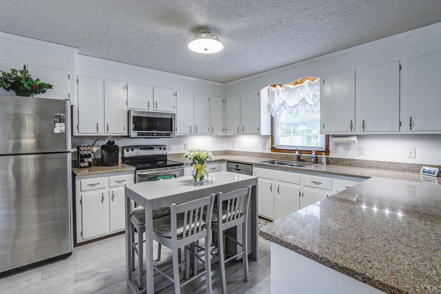 759 Farfields Drive Lynchburg, VA 24502 - Photo 13 of 53 a kitchen with kitchen island granite countertop stainless steel appliances a refrigerator a sink a stove a table and chairs