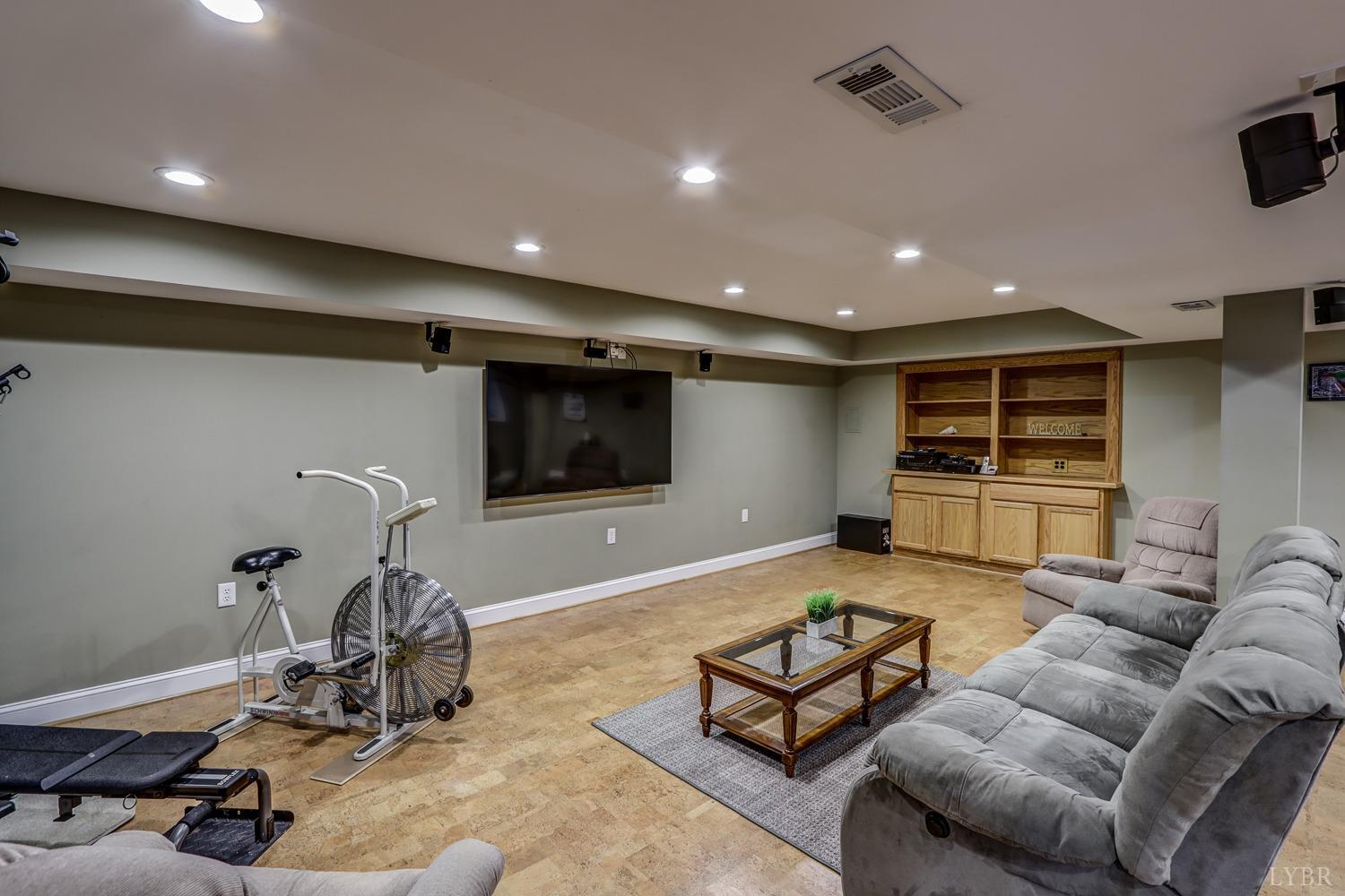 759 Farfields Drive Lynchburg, VA 24502 - Photo 38 of 53 a living room with furniture a flat screen tv and gym equipment