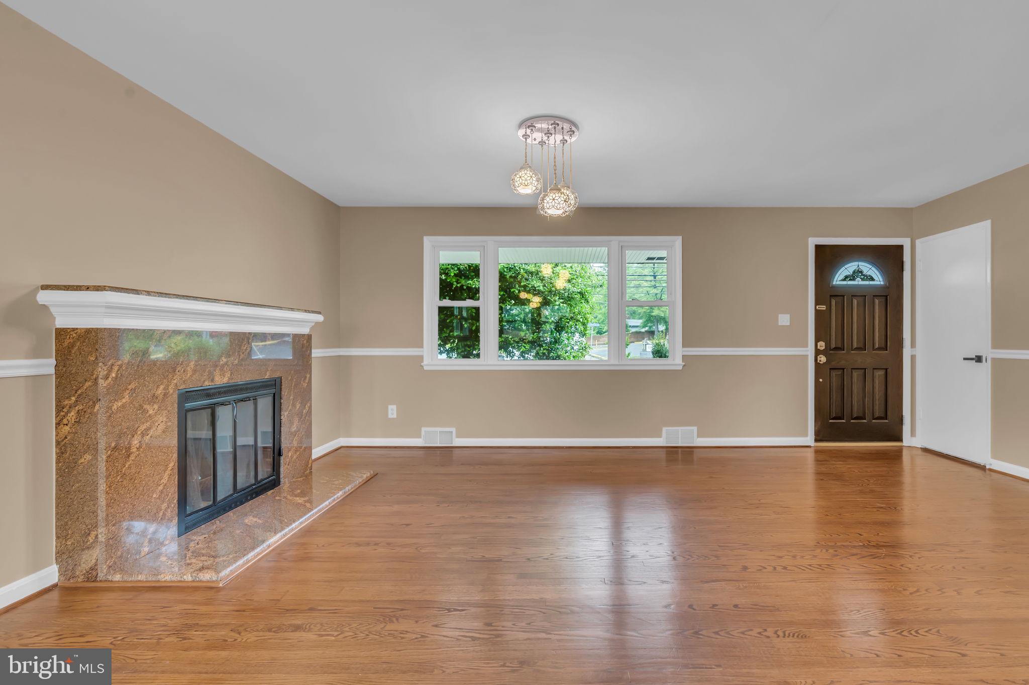 6809 Braddock Road Springfield, VA 22151 - Photo 11 of 60 an empty room with wooden floor fireplace and windows