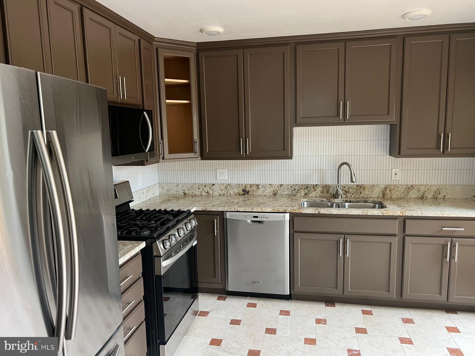 6809 Braddock Road Springfield, VA 22151 - Photo 16 of 60 a kitchen with granite countertop a refrigerator stove and sink