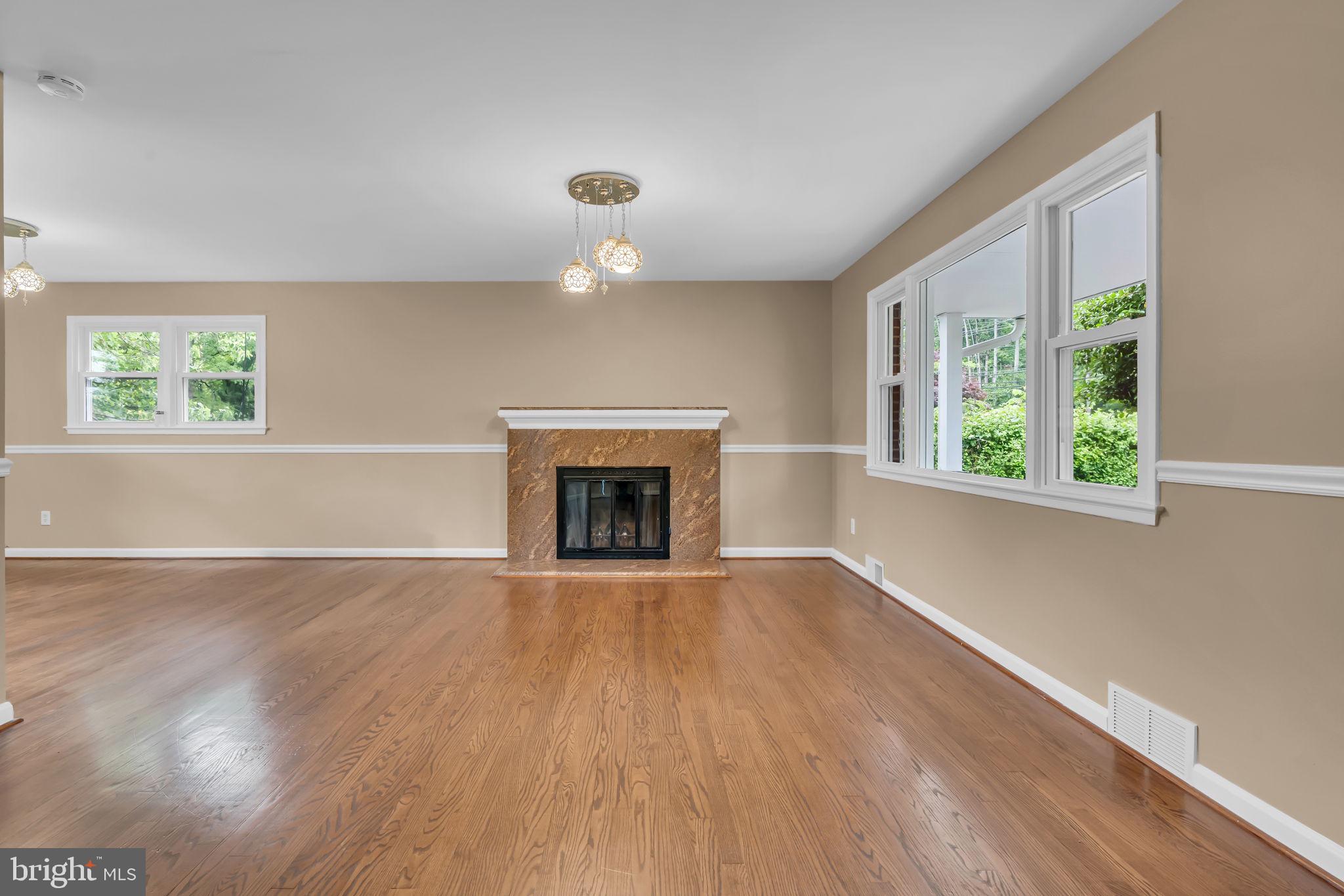 6809 Braddock Road Springfield, VA 22151 - Photo 8 of 60 an empty room with wooden floor a fireplace and windows