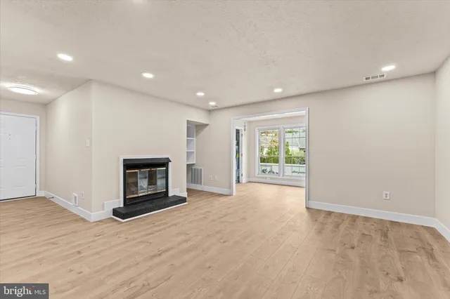 a view of empty room with wooden floor and fireplace