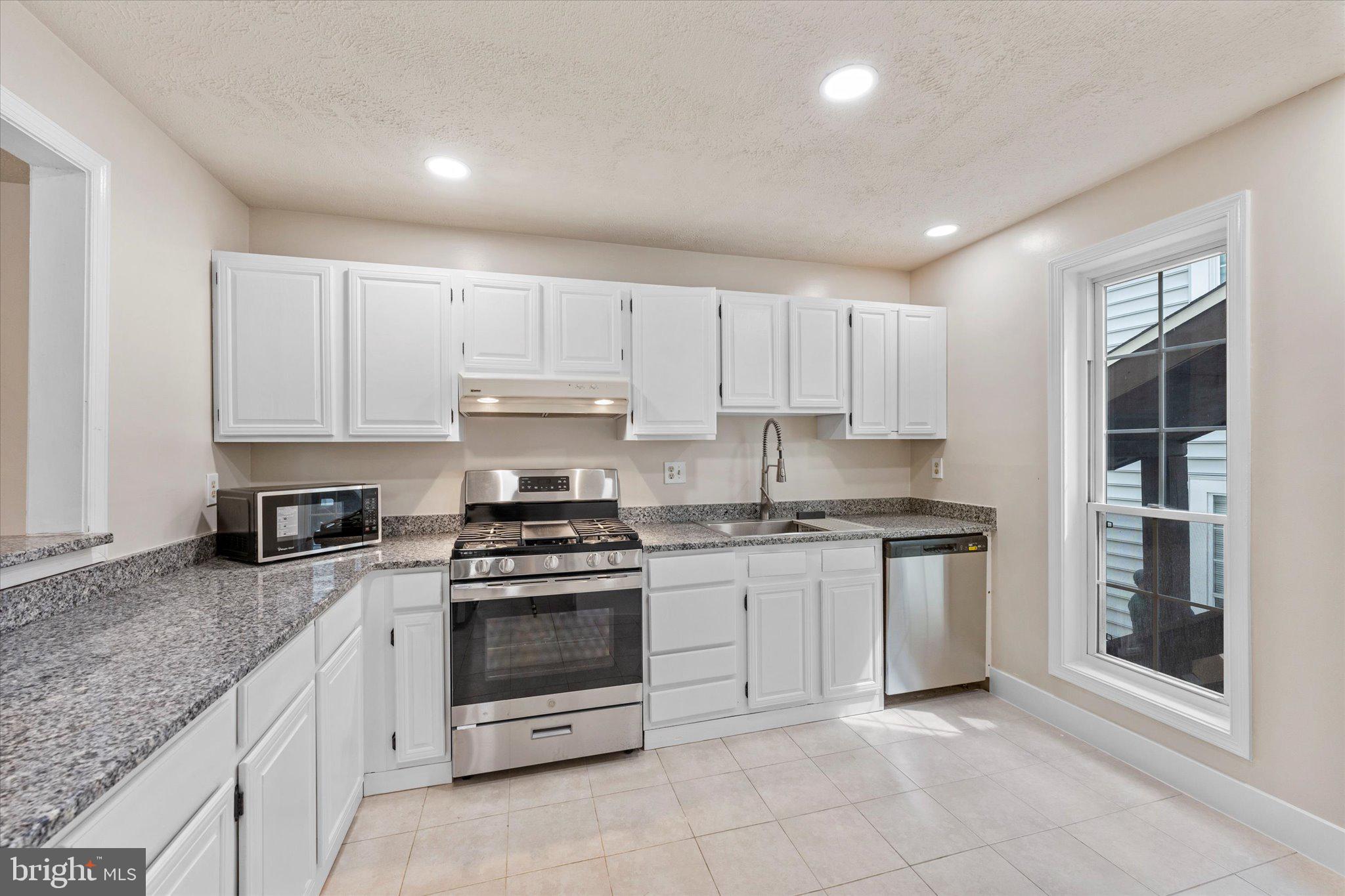 10066 Oakton Terrace Road, Unit 10066 Oakton, VA 22124 - Photo 8 of 27 a kitchen with granite countertop white cabinets and stainless steel appliances