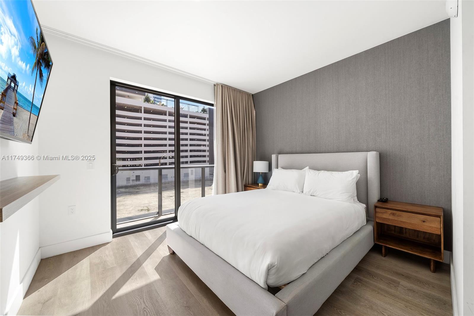 229 Southwest 9th Street, Unit 208 Miami, FL 33130 - Photo 2 of 22 a large bed sitting in a bedroom next to a window