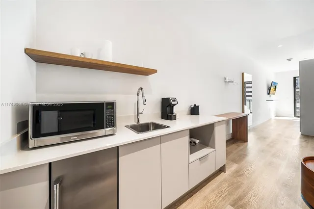 a kitchen with stainless steel appliances a stove and white cabinets