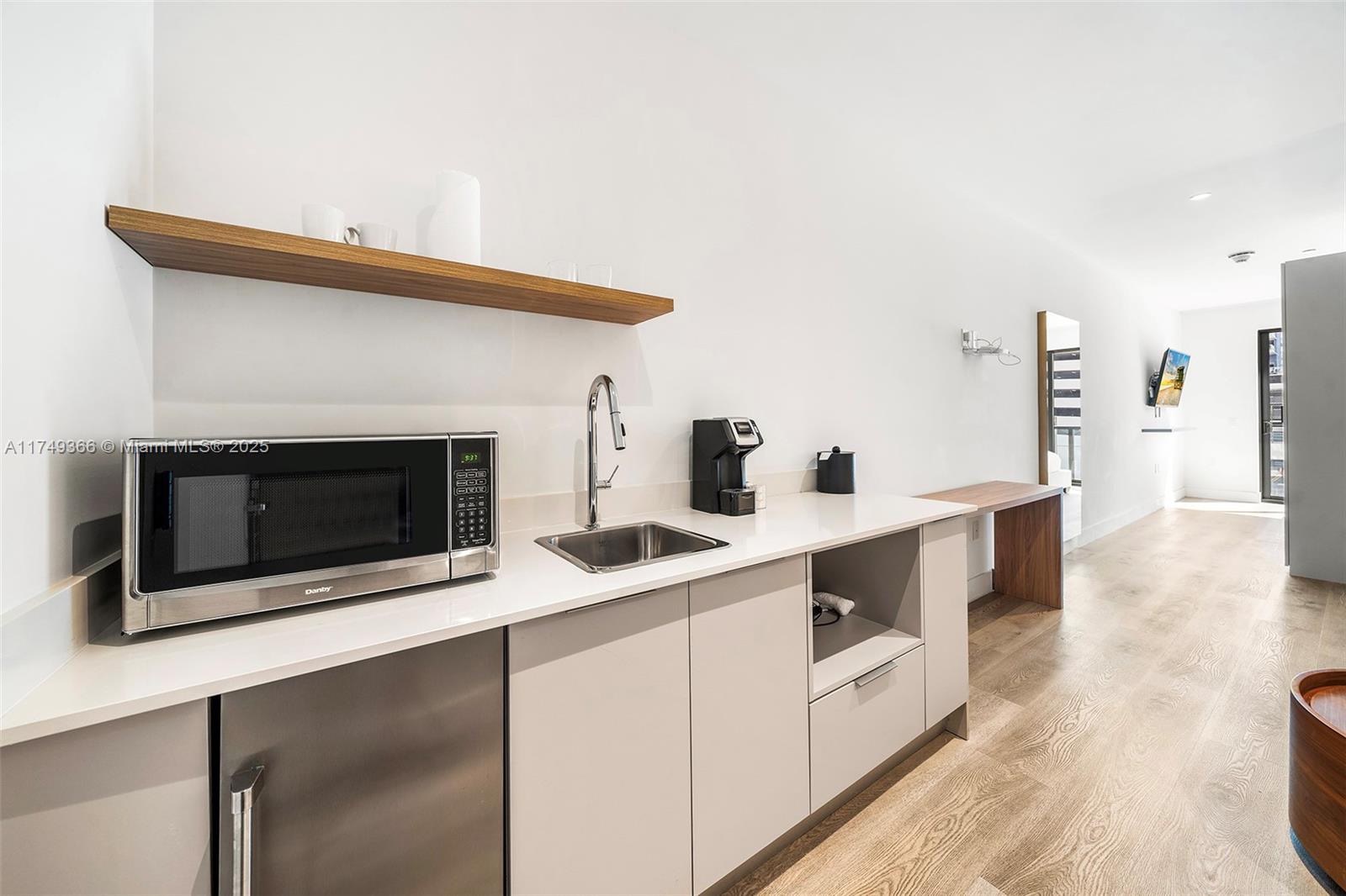 229 Southwest 9th Street, Unit 208 Miami, FL 33130 - Photo 6 of 22 a kitchen with stainless steel appliances a stove and white cabinets