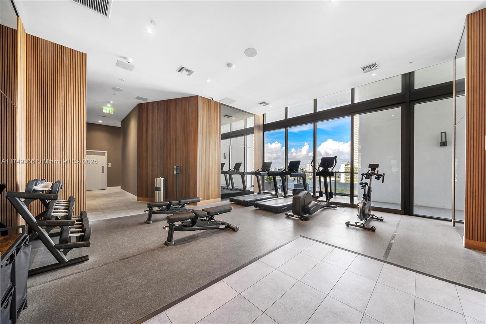 229 Southwest 9th Street, Unit 208 Miami, FL 33130 - Photo 8 of 22 a view of a gym equipment and floor to ceiling window