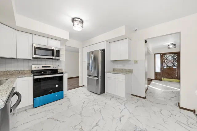 a kitchen with kitchen island granite countertop a refrigerator stove and sink