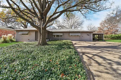 a front view of a house with a tree and a yard