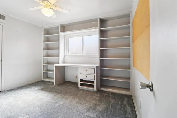a view of an empty room with a cabinet and a window
