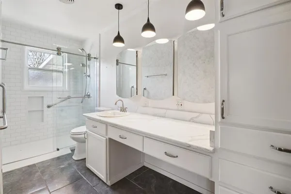 a bathroom with a sink a toilet and shower