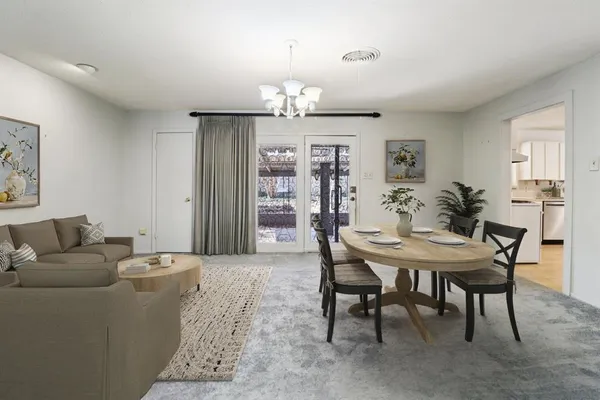 a living room with furniture a chandelier and a dining room