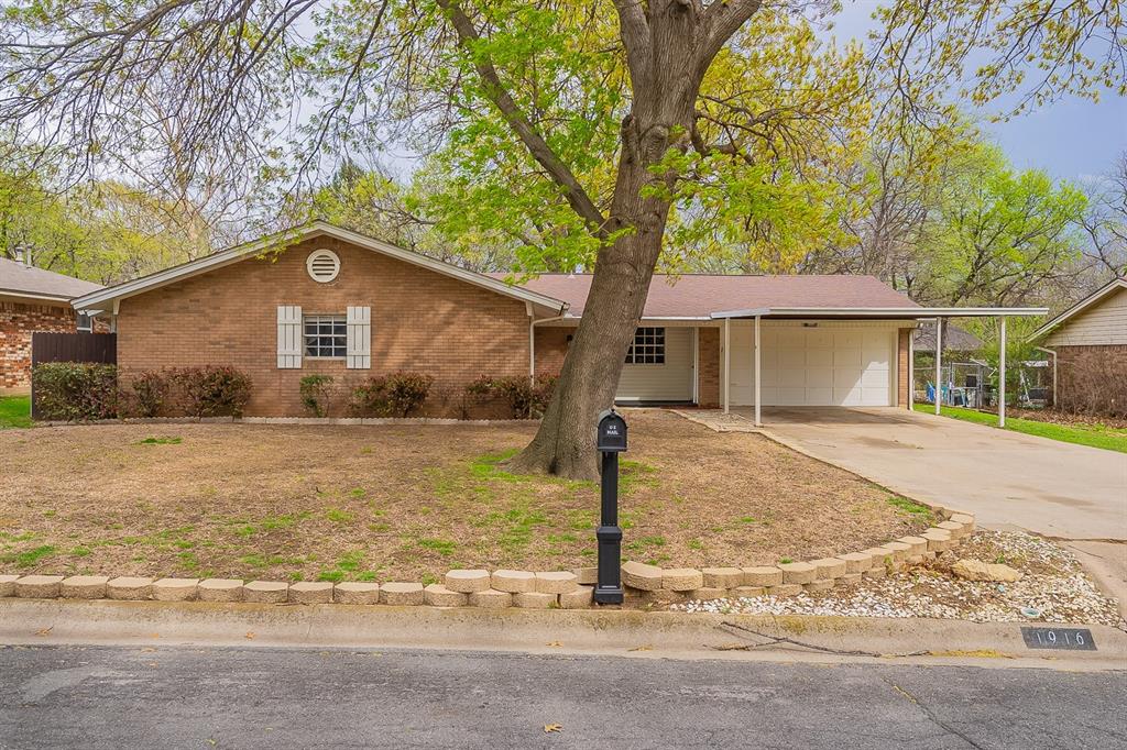 a front view of house with yard and trees around
