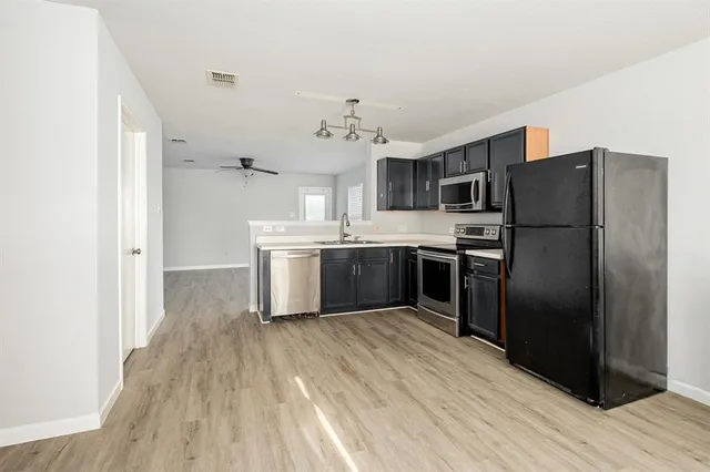 a kitchen with stainless steel appliances a refrigerator sink and cabinets