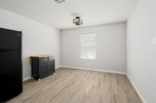 an empty room with wooden floor and a window