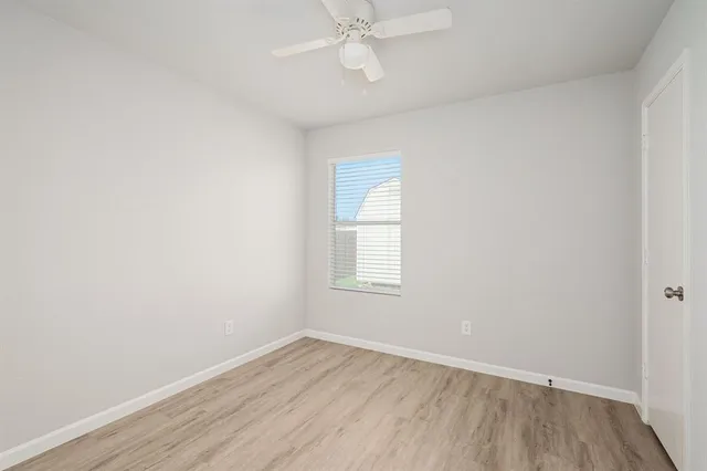 an empty room with a window and wooden floor