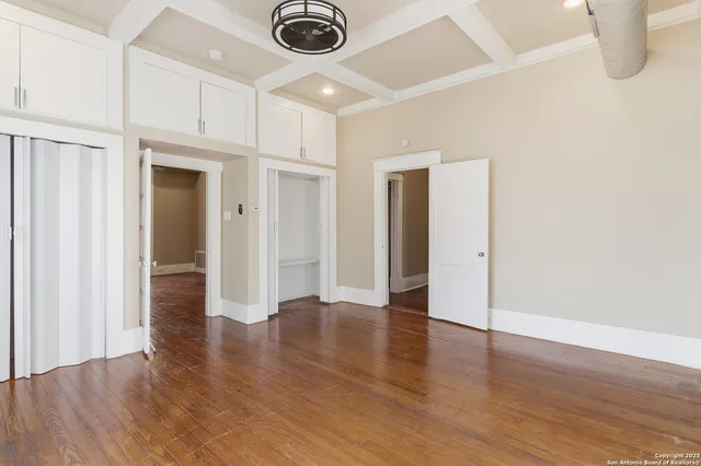a view of an empty room with wooden floor