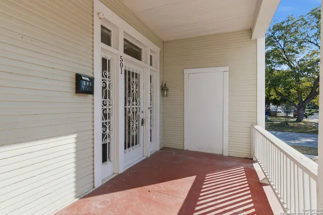 a view of a hallway with wooden floor and a balcony