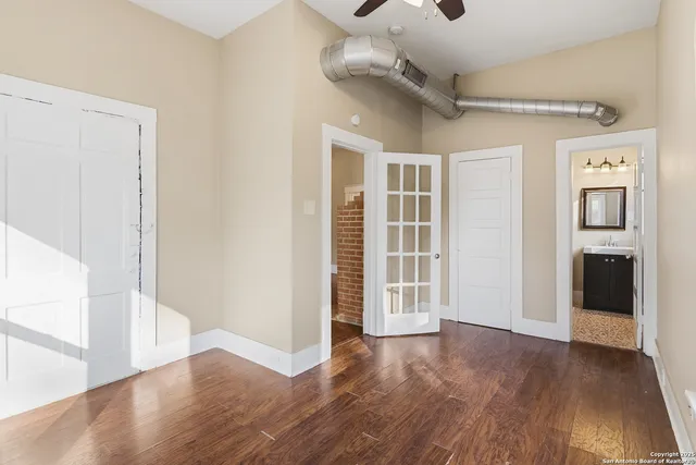 an empty room with wooden floor and windows