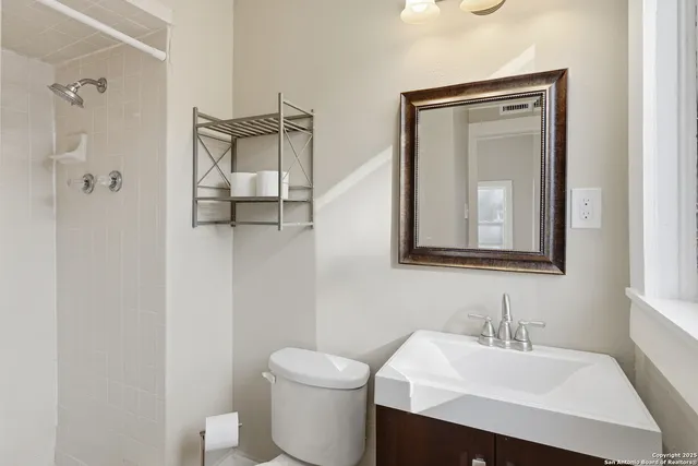a bathroom with a toilet sink and mirror