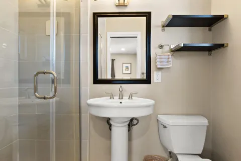 a bathroom with a toilet sink and mirror