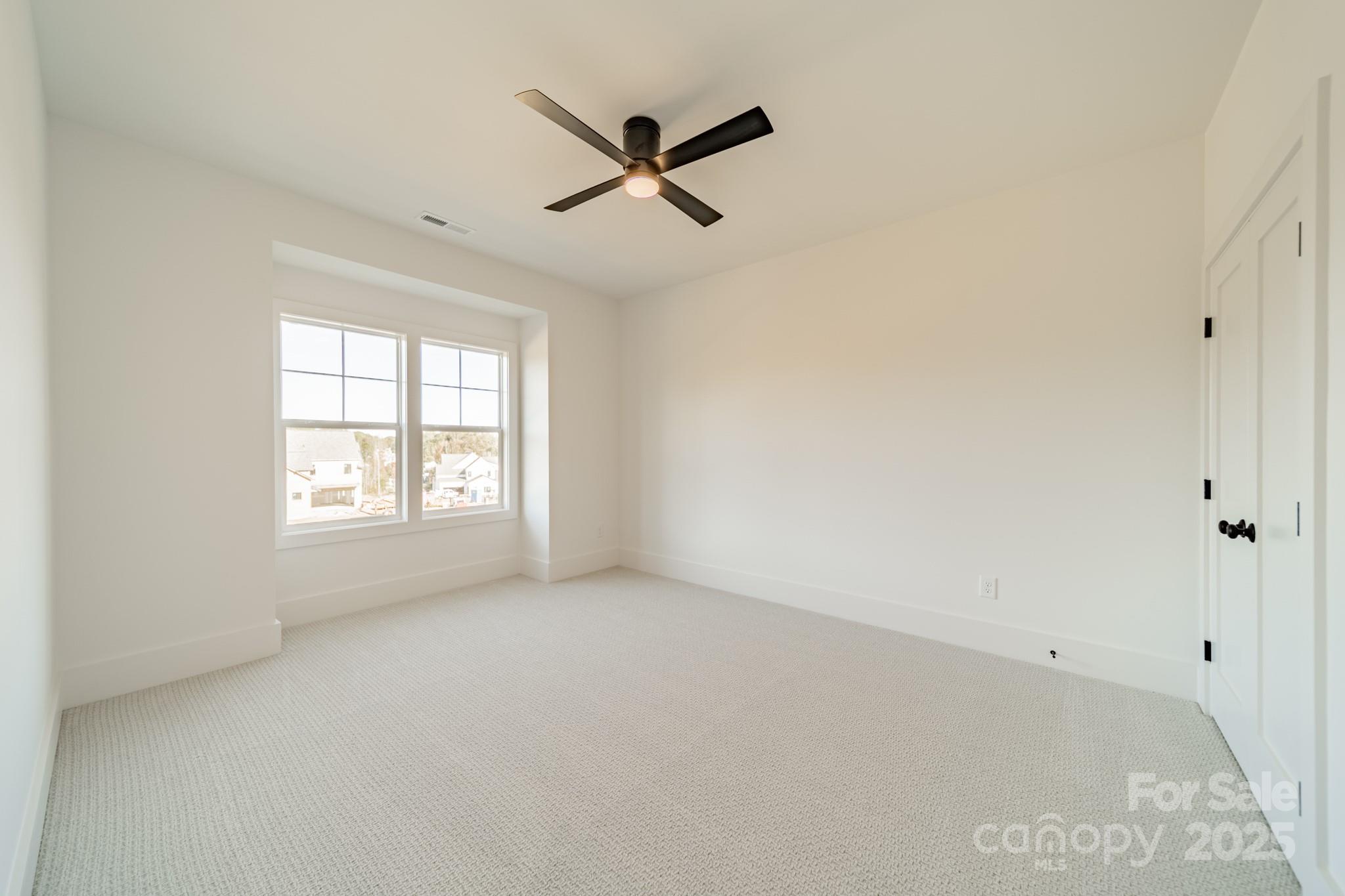 19032 Newburg Hill Road, Unit 23 Davidson, NC 28036 - Photo 38 of 39 an empty room with ceiling fan and windows