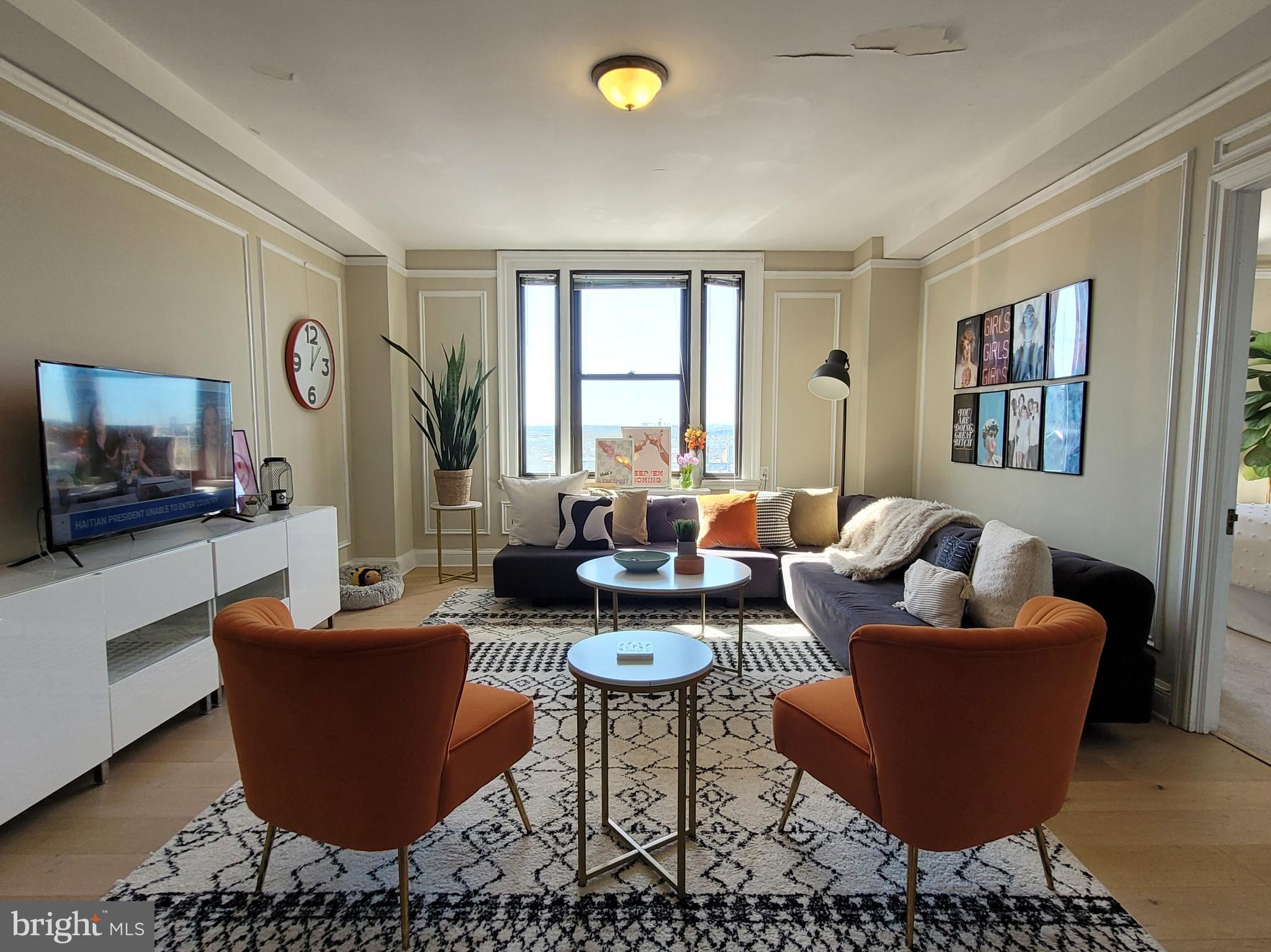 2031 Locust Street, Unit 802 Philadelphia, PA 19103 - Photo 2 of 26 a living room with furniture and a flat screen tv