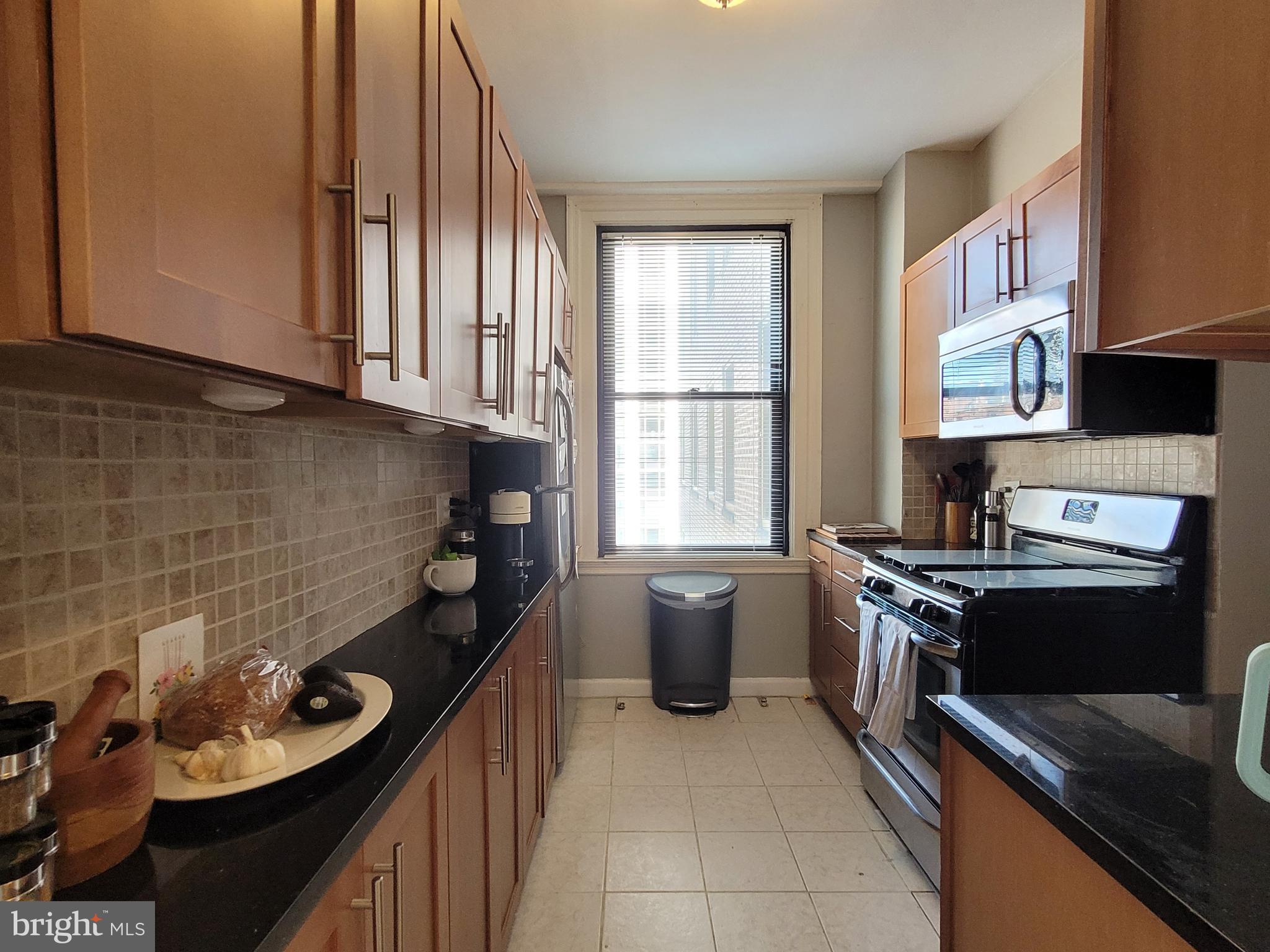 2031 Locust Street, Unit 802 Philadelphia, PA 19103 - Photo 5 of 26 a kitchen with stainless steel appliances granite countertop a sink stove and cabinets
