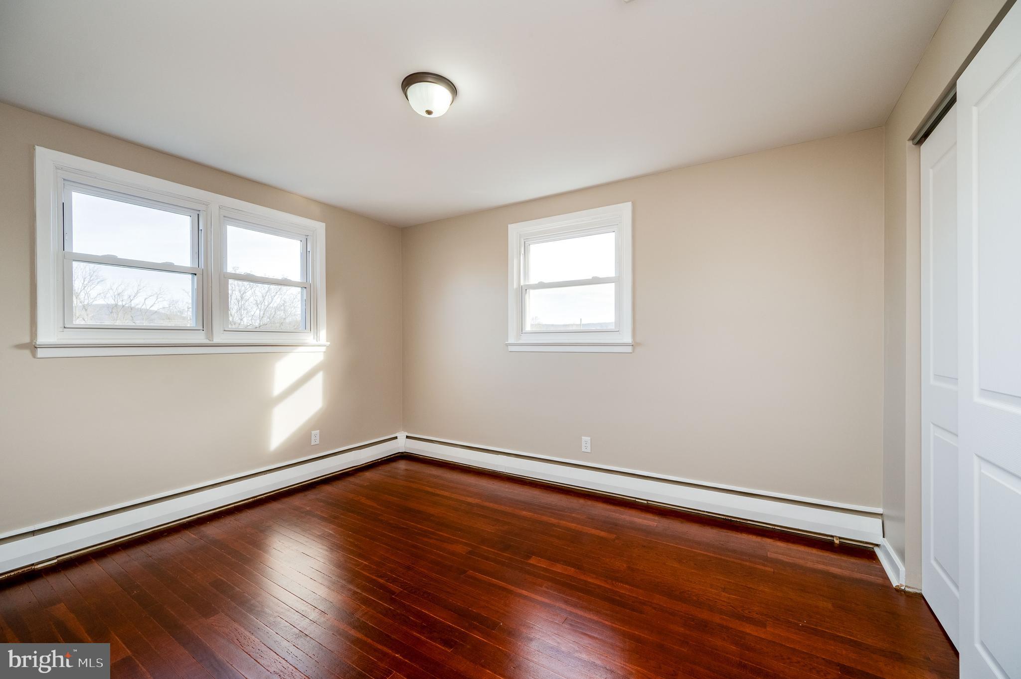 3346 Sheidy Avenue Reading, PA 19605 - Photo 16 of 35 an empty room with wooden floor and windows