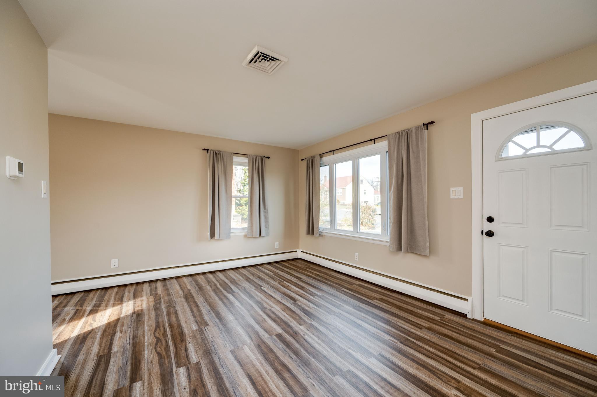 3346 Sheidy Avenue Reading, PA 19605 - Photo 6 of 35 a view of an empty room with wooden floor and a window