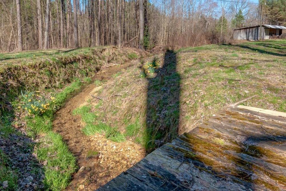 72 Denson Road Lawrenceburg, TN 38464 - Photo 25 of 30 Walking towards the back of the property is the winding stream and rustic wood bridge leading to the larger barn.