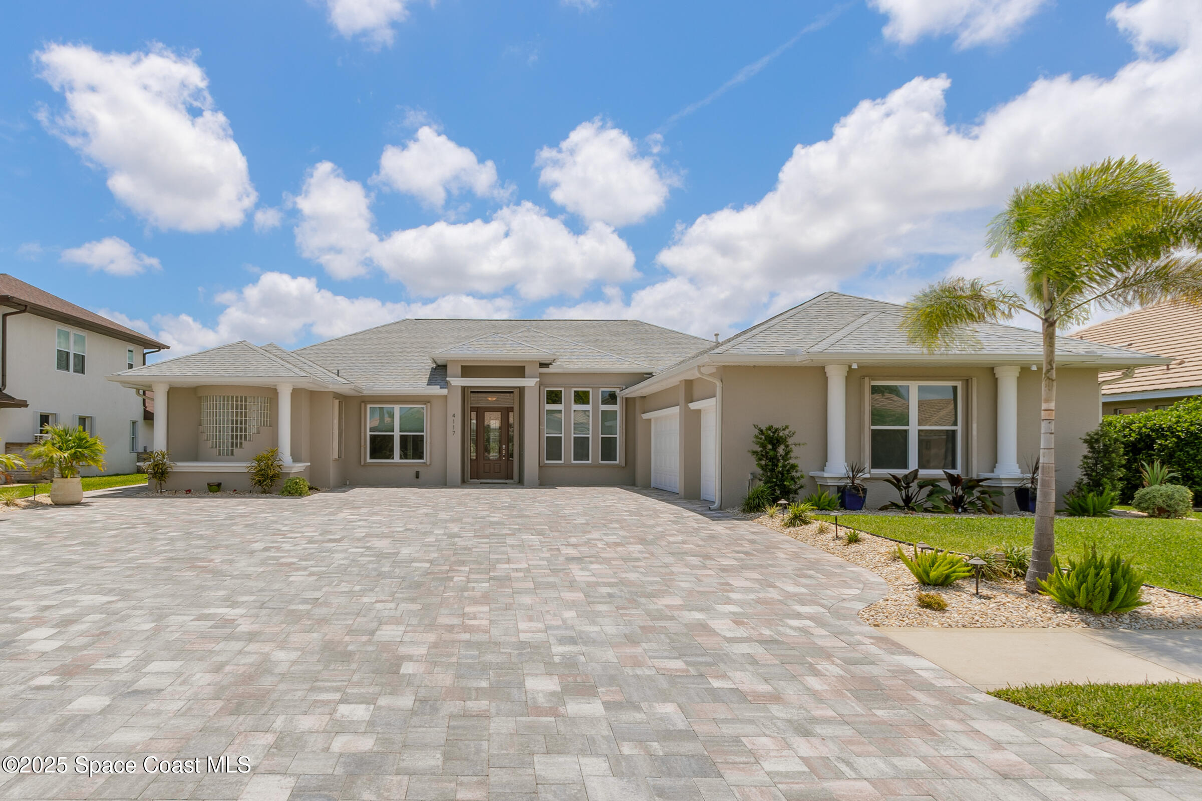 a view of a house with a patio and a yard